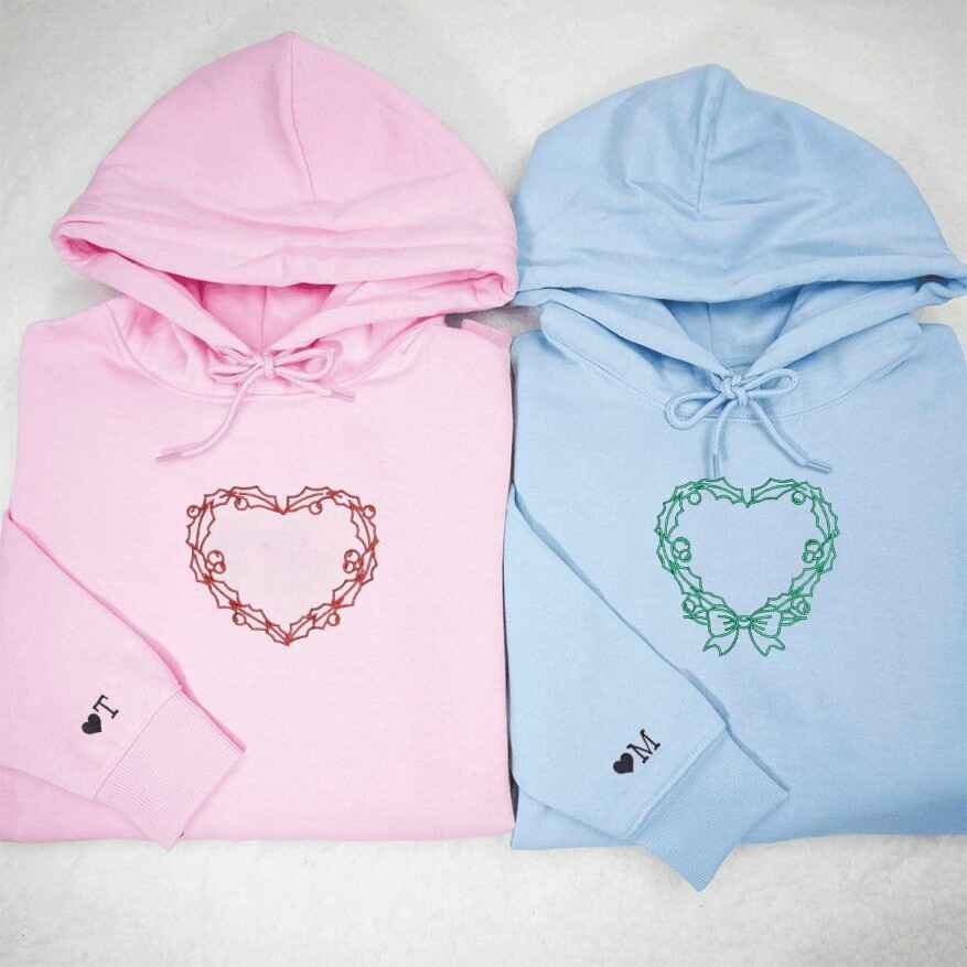 Matching pink and blue couple hoodies with heart wreath embroidery
