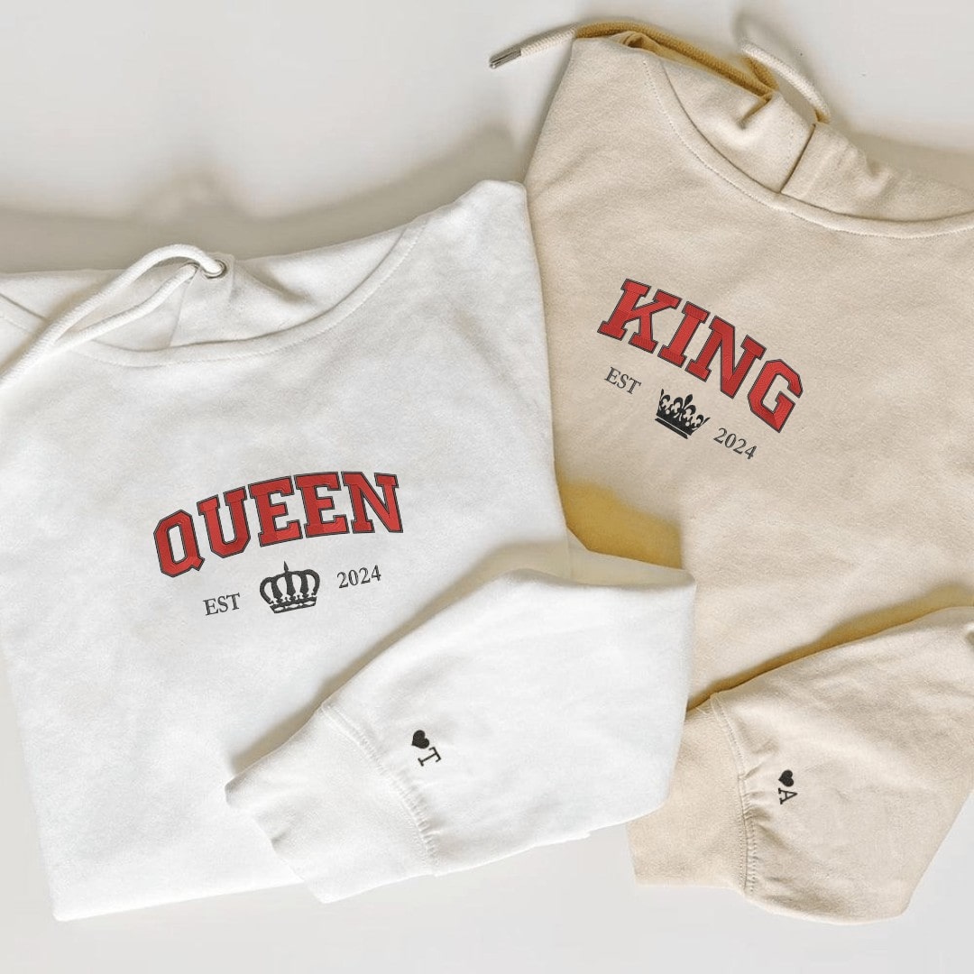 Neutral-toned Queen and King hoodies showcasing heart and initial embroidery on sleeves.