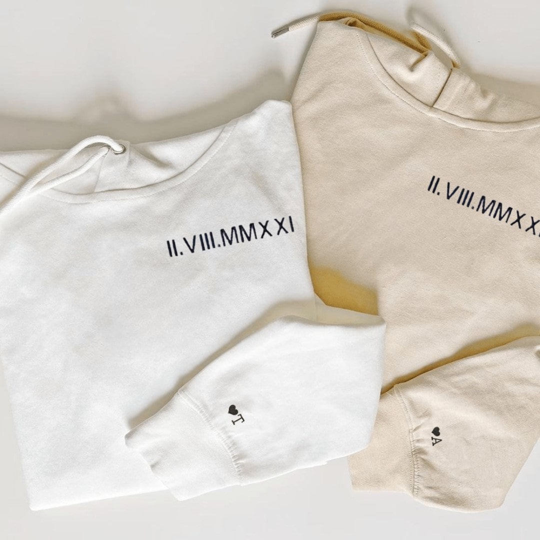 Close-up of Roman numeral anniversary date embroidery on couple hoodies