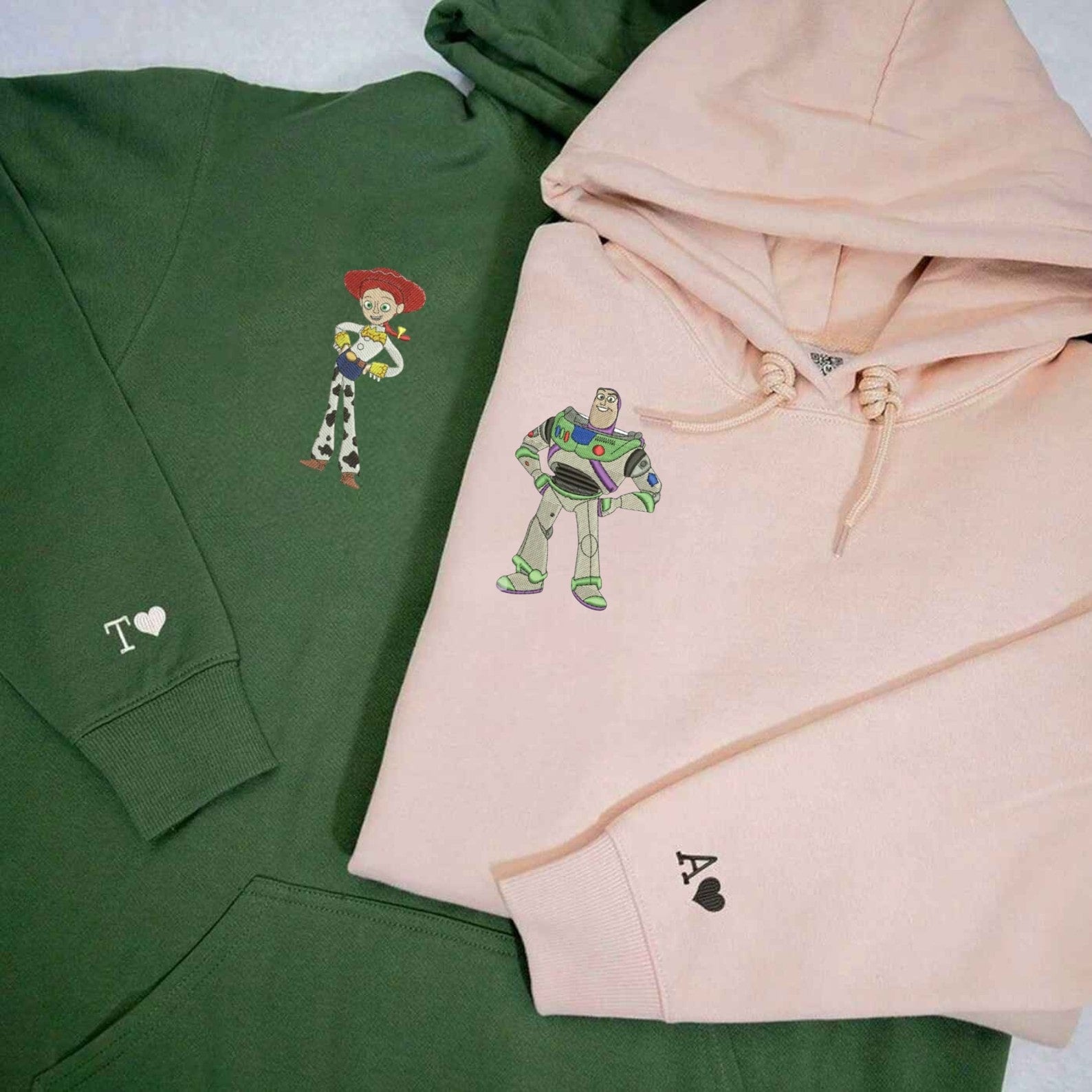 Embroidered Buzz Lightyear and Jessie on brown hoodie and white sweatshirt.