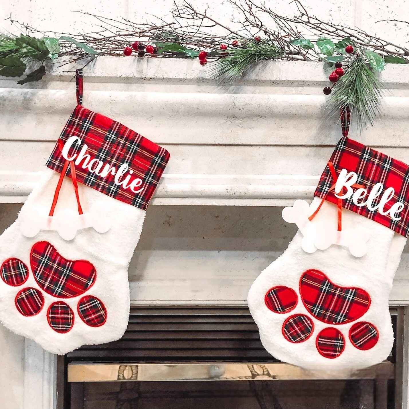 Festive holiday stockings for pets featuring red plaid paw design
