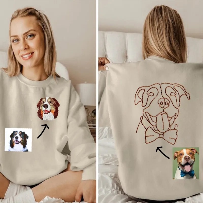 Hand-drawn dog portraits embroidered on a cozy beige sweatshirt.
