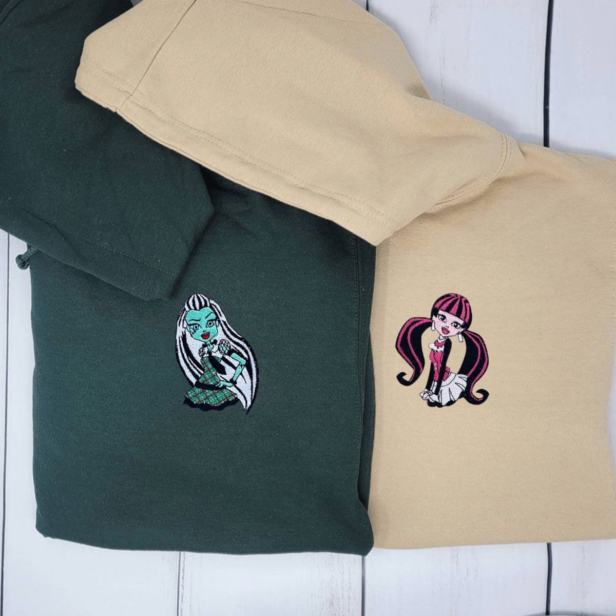 Personalized couple hoodies with fun monster-themed embroidery and heart symbols.