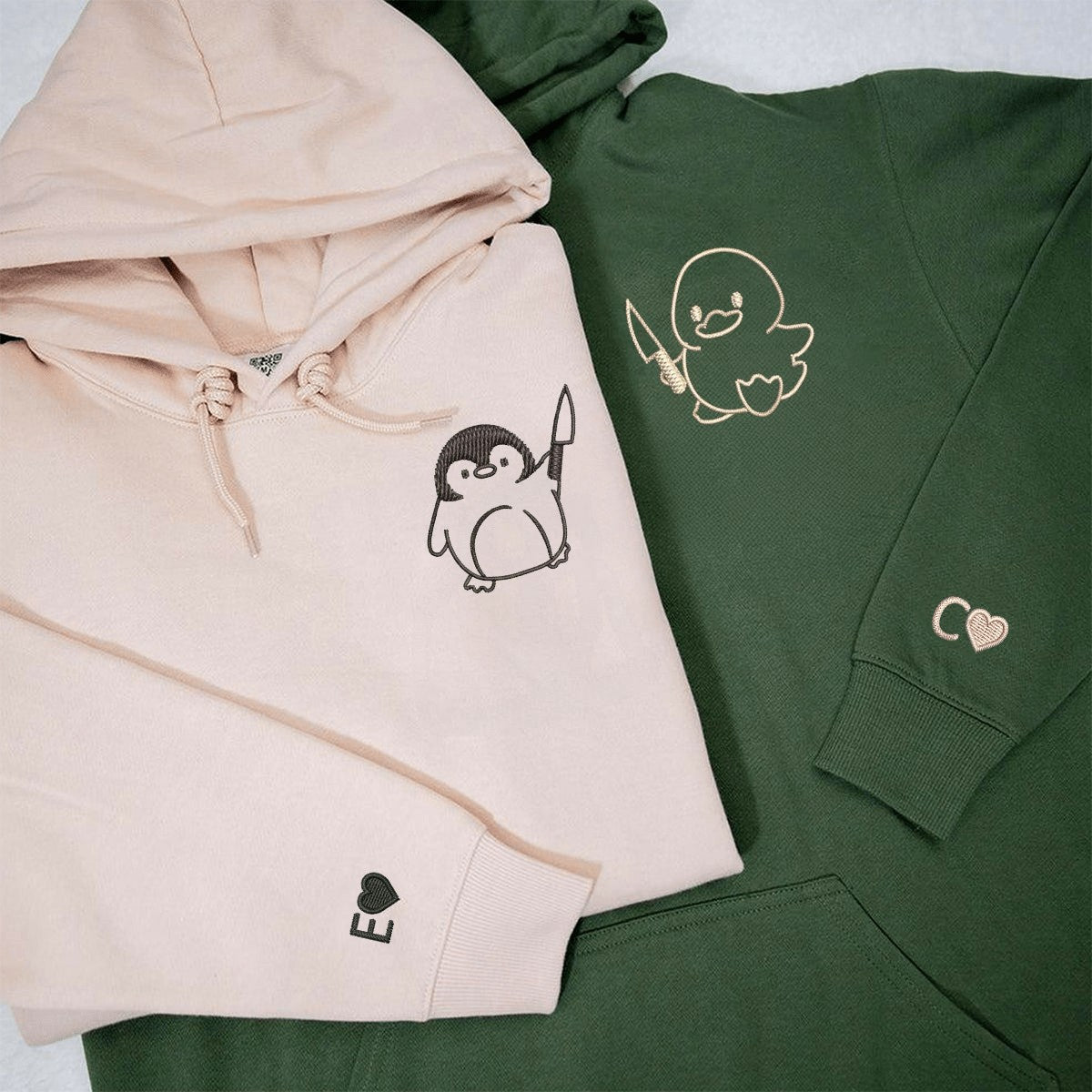 Duck and penguin with knife design on black and beige hoodies