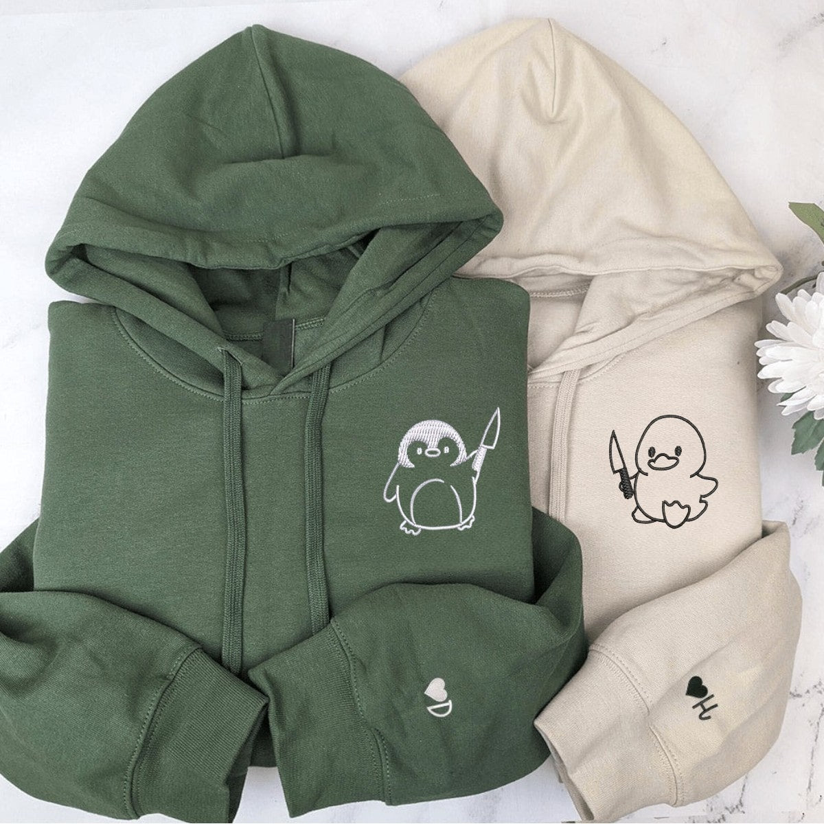 Playful duck and penguin cartoon graphic hoodies with knife designs