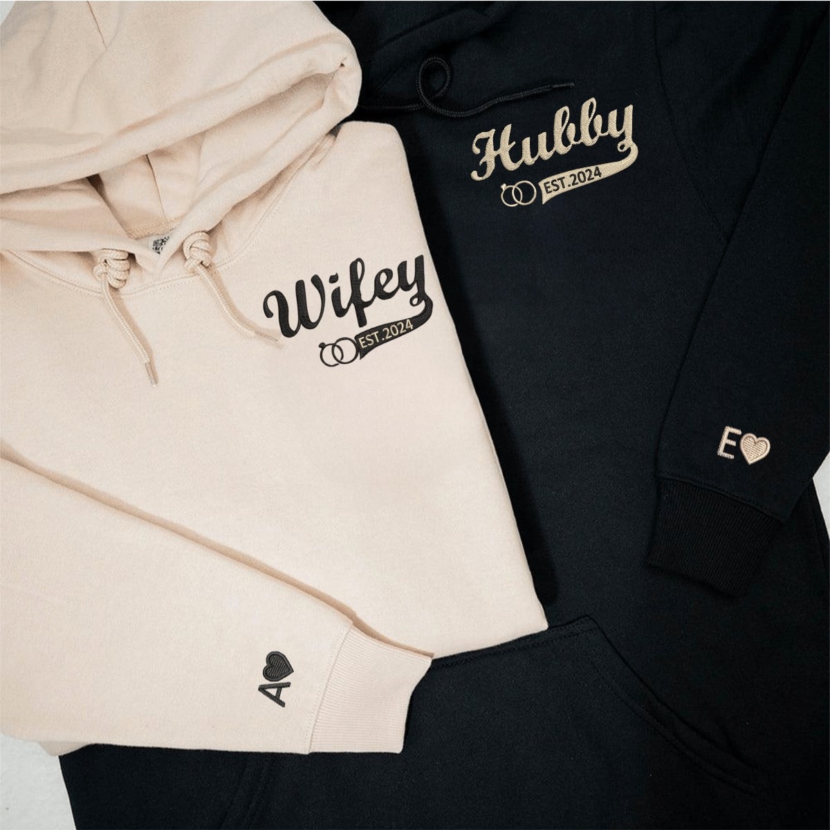 Matching Hubby and Wifey hoodies with embroidered names and heart details on cuffs.