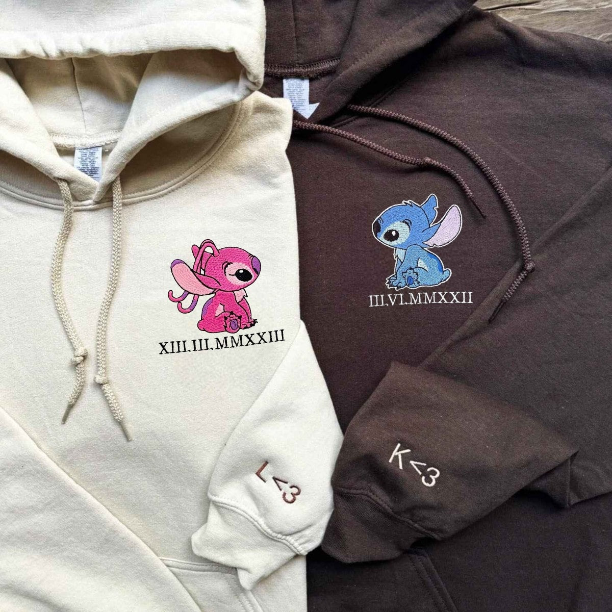 Couple hoodies with embroidered pink and blue characters and meaningful Roman numeral dates.