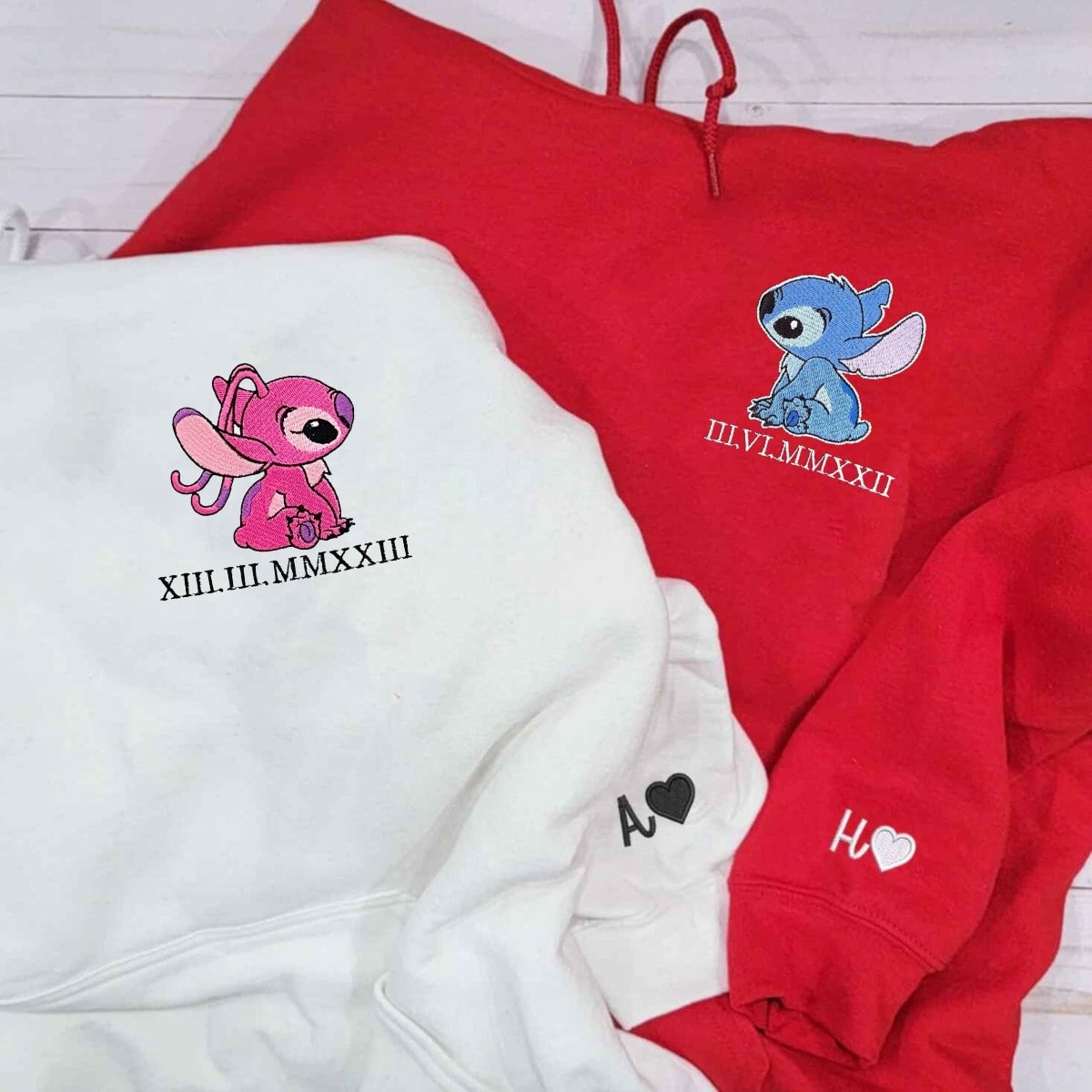 Matching couple hoodies designed with custom initials, heart symbols, and playful character details.