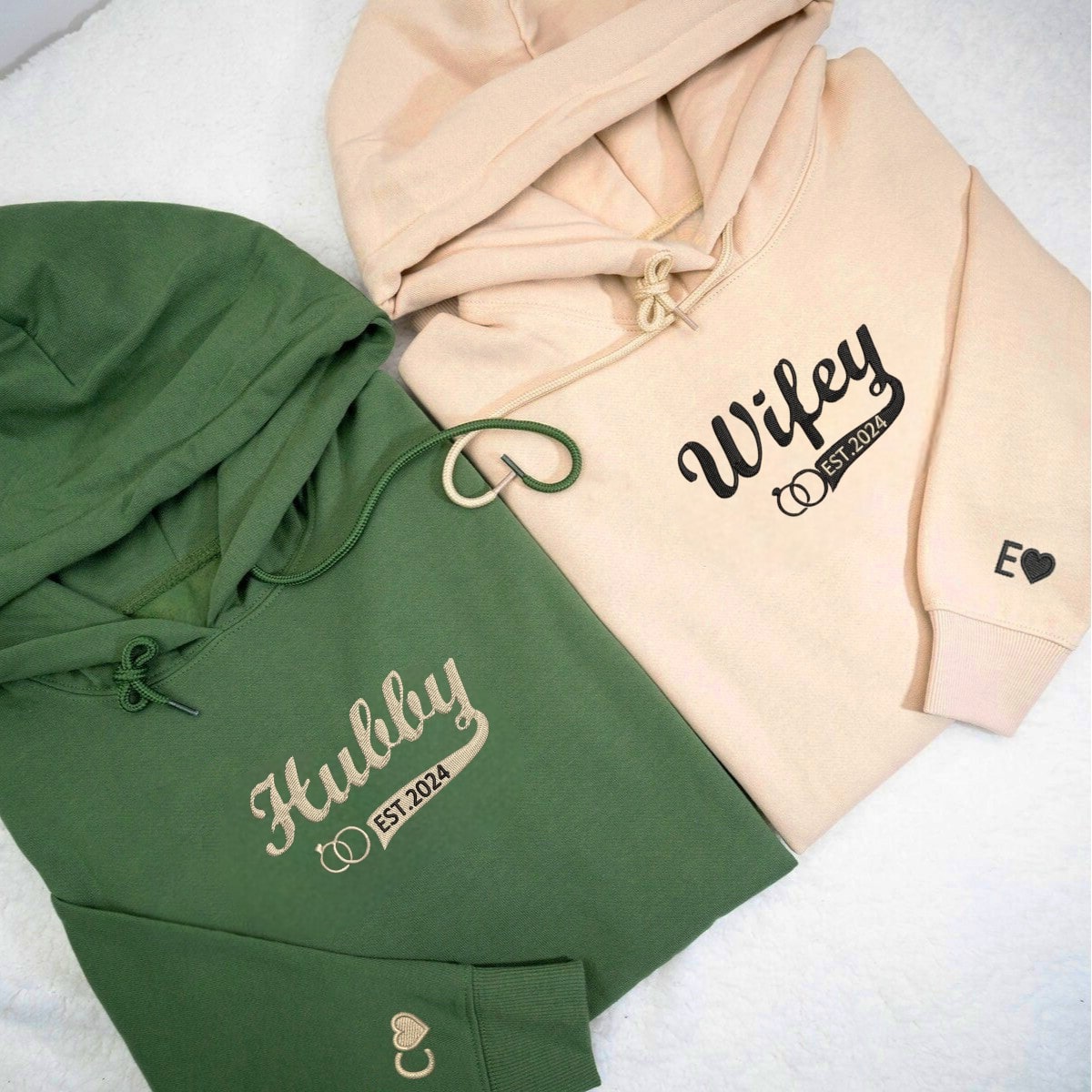 Customized couple hoodies featuring 'Wifey' and 'Hubby' labels with wedding symbols.