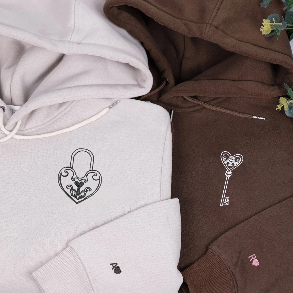 Elegant couple hoodies with embroidered heart lock and key symbols on the front.