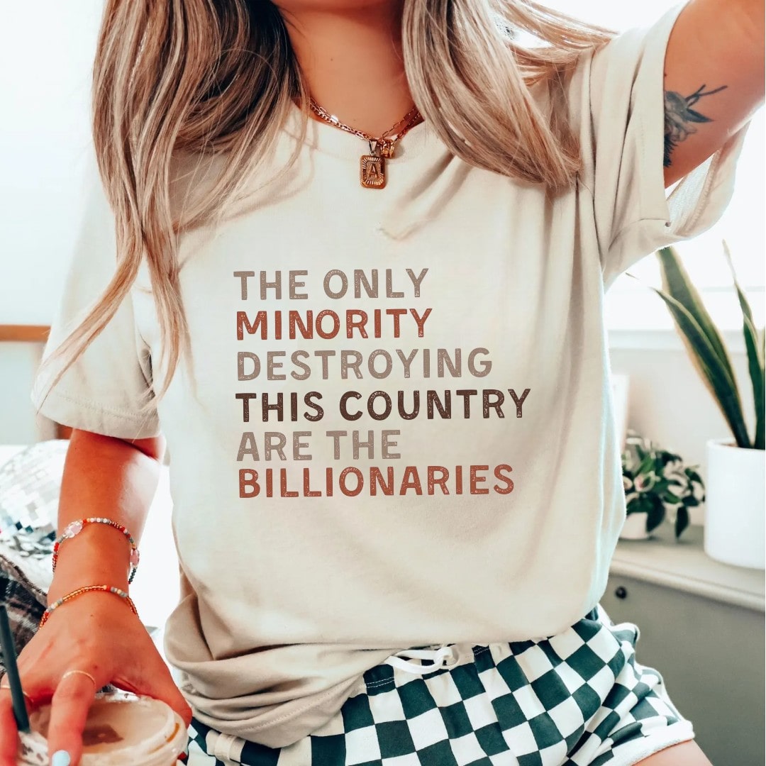 Beige "The Only Minority Destroying This Country" tee featuring a bold quote.
