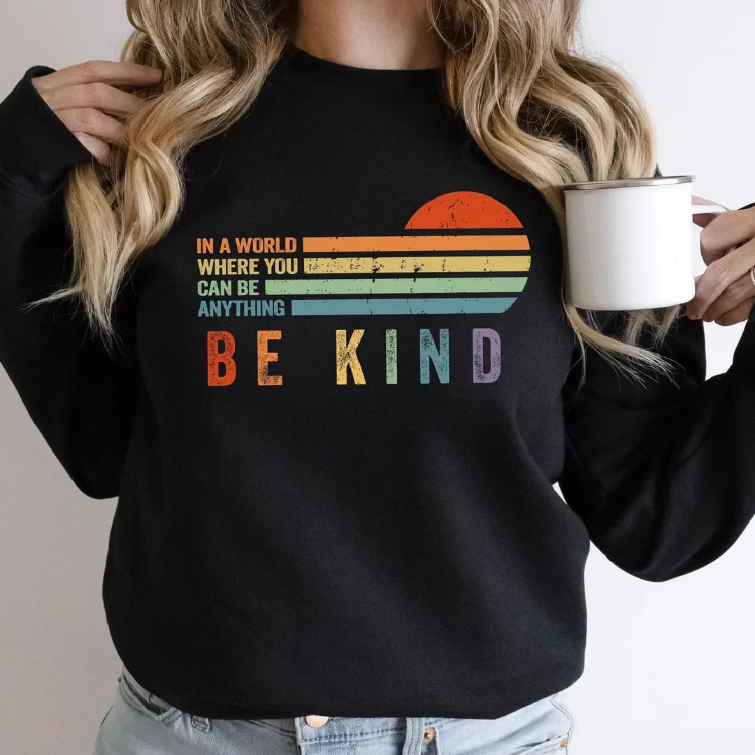 Black "Be Kind" sweatshirt with inspirational message and rainbow design