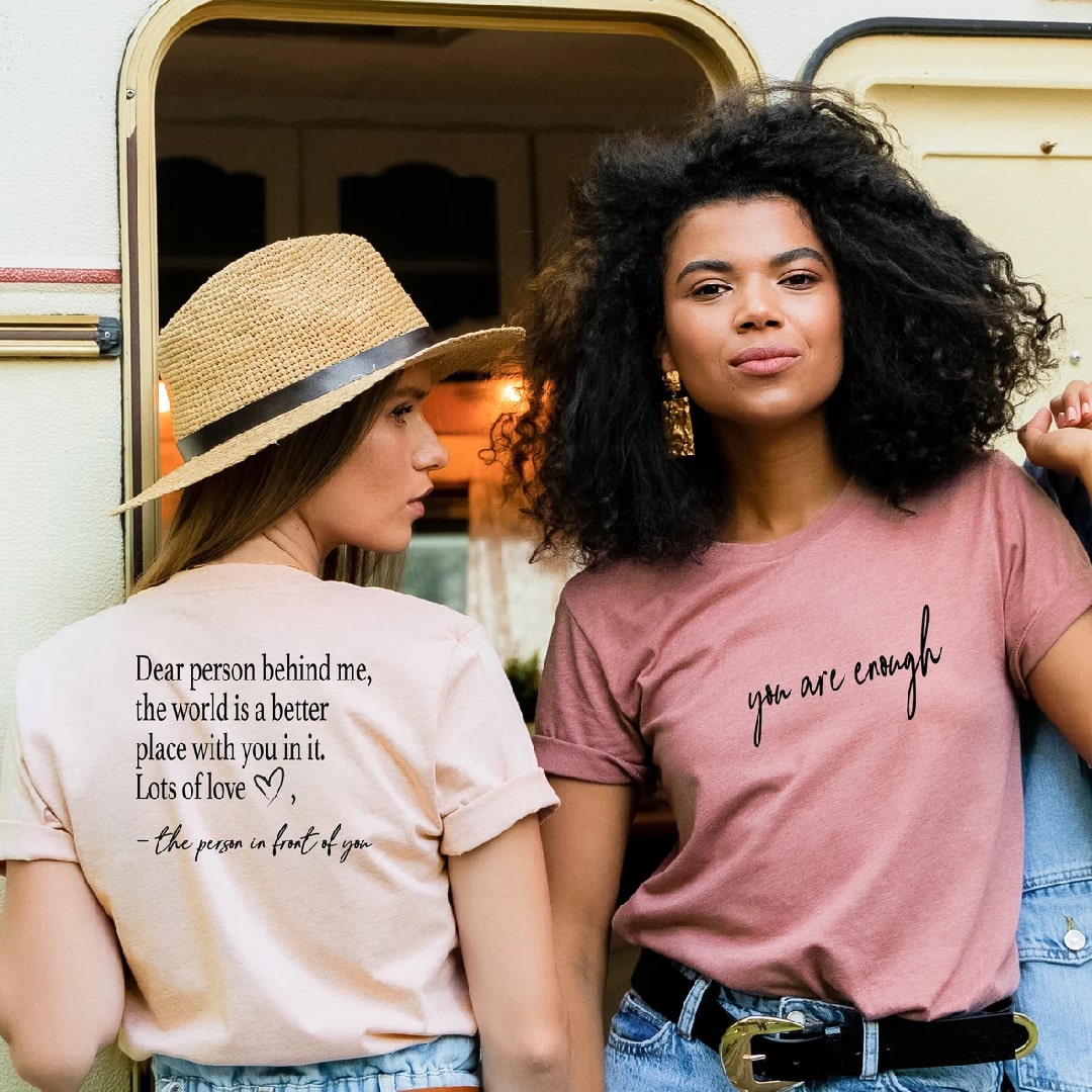 "You Are Enough" T-shirt in earthy pink, styled with denim overalls.
