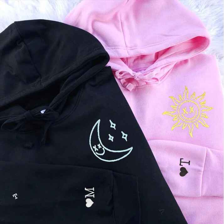 Matching "Sun and Moon" couple hoodies in pink and black with detailed celestial embroidery.
