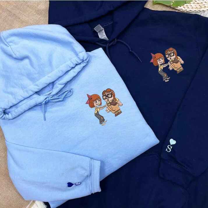 Fun and whimsical couple hoodies with embroidered adventure-inspired characters, perfect for exploring together.
