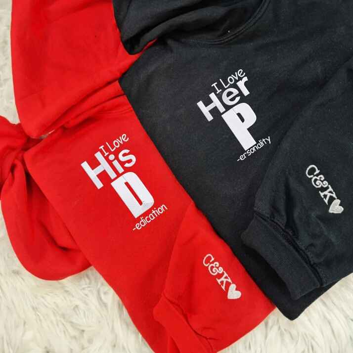 "I Love His Dedication" and "I Love Her Personality" couple hoodies in cozy white and maroon, perfect for couples.
