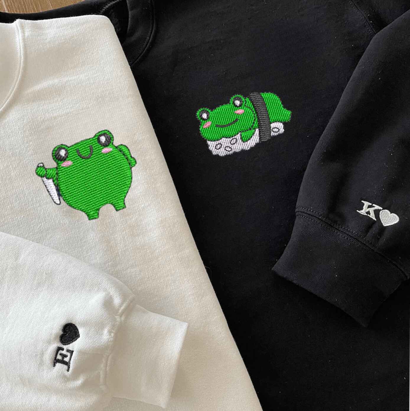 Matching couple hoodies with embroidered frog chef and sushi designs
