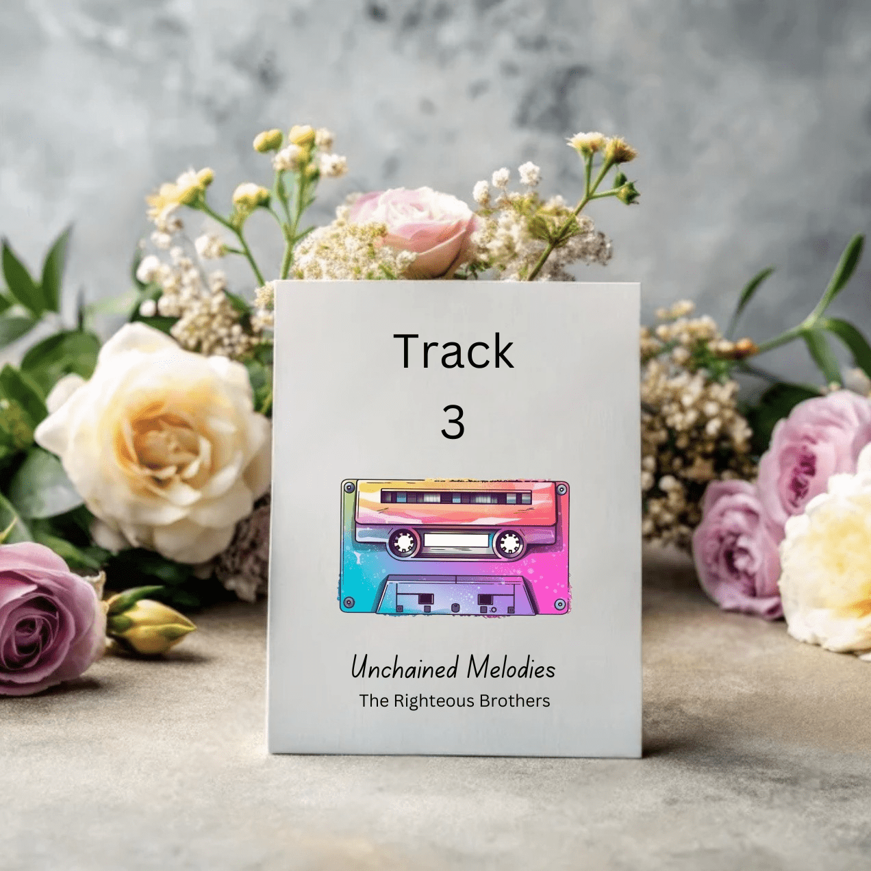 Music-inspired table number with vibrant cassette artwork and song title