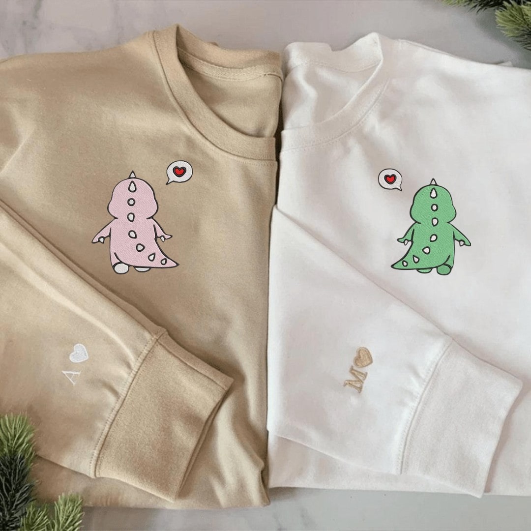 Cute couple sweatshirts featuring playful dino designs.
