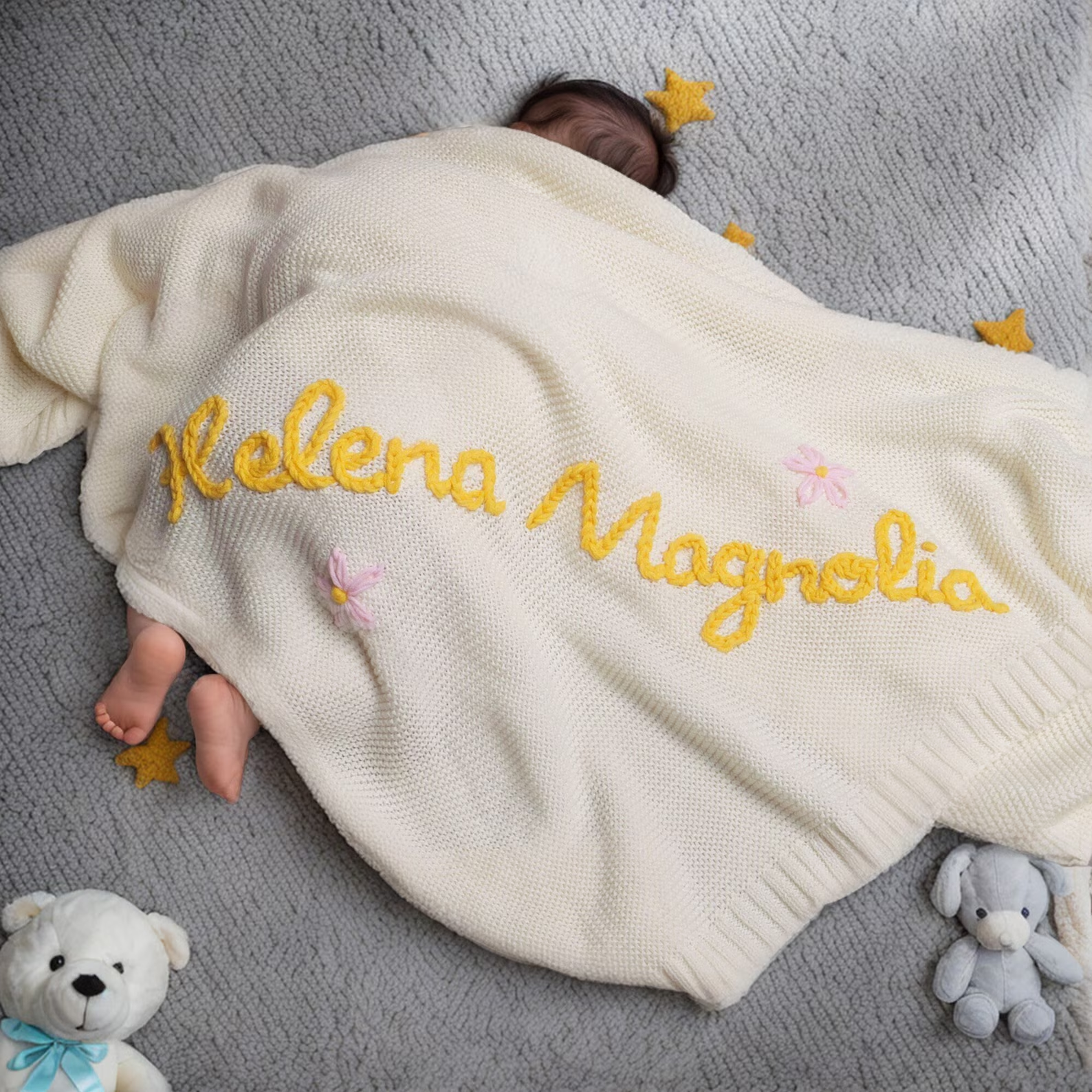 Baby sleeping under a custom 30x40-inch blanket with their name on it.