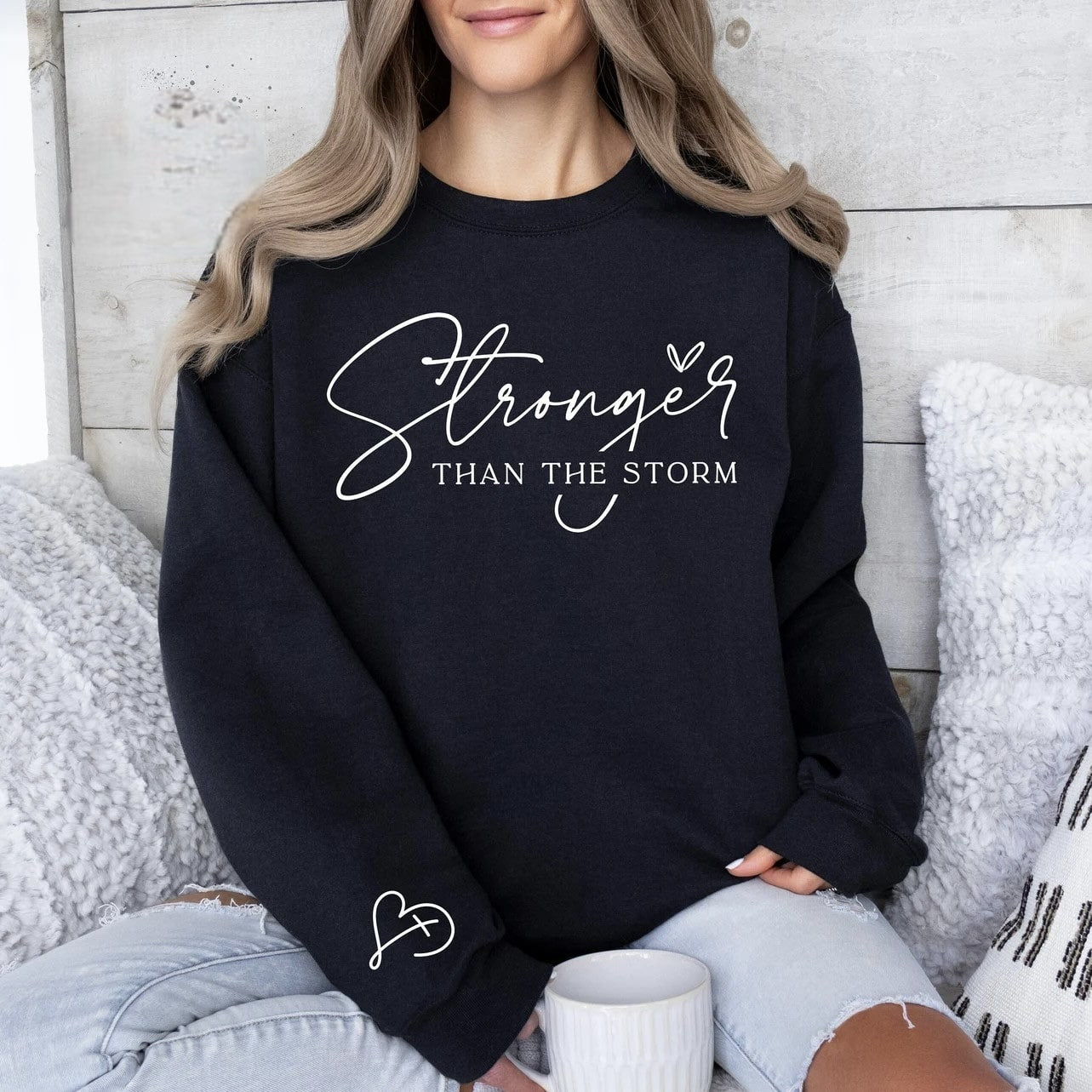 Black "Stronger Than the Storm" sweatshirt with inspirational script.
