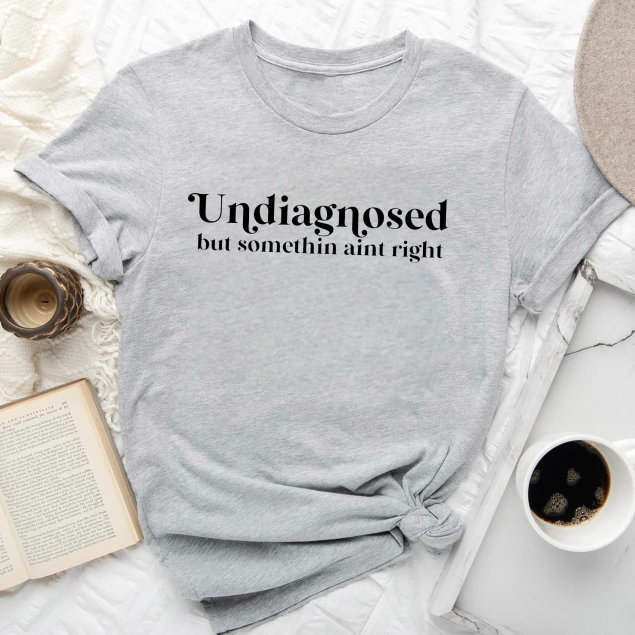  Undiagnosed But Somethin' Ain't Right T-shirt in light gray with book and coffee accessories