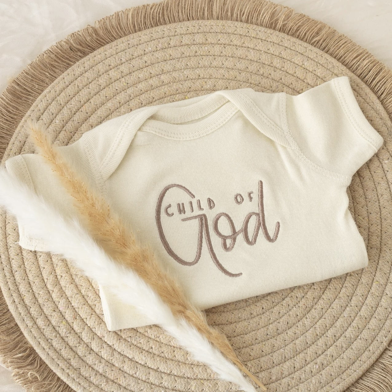 Baby Onesie 'Child of God' on Round Beige Rug