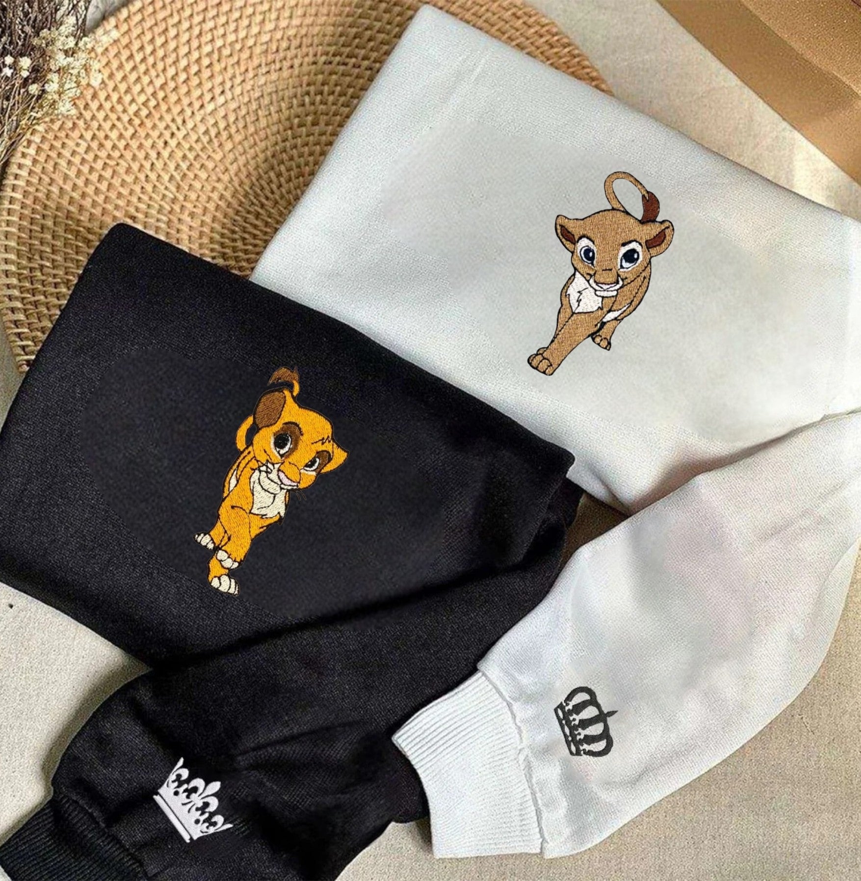 Stylish and playful couple sweatshirts with embroidered lion cub characters.