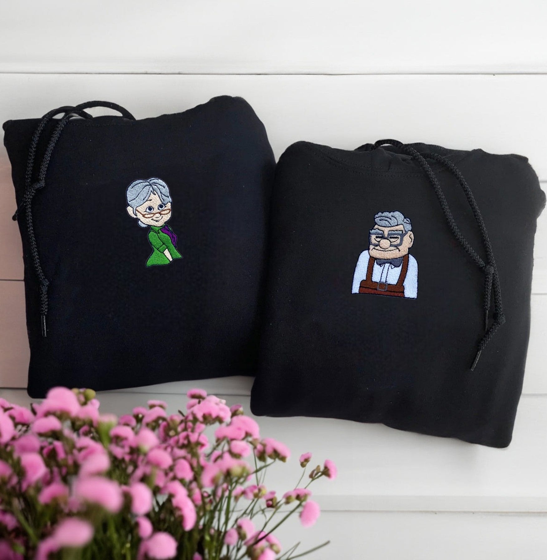 Matching Movie Character Couple Hoodies with timeless embroidered designs and heart symbols.