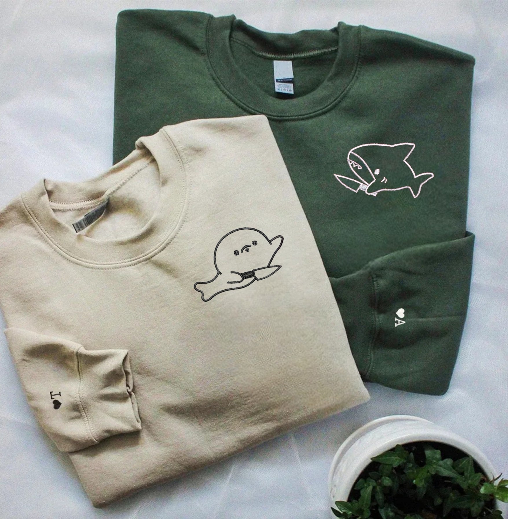 Adorable couple sweatshirts with personalized initials and playful cartoon designs.