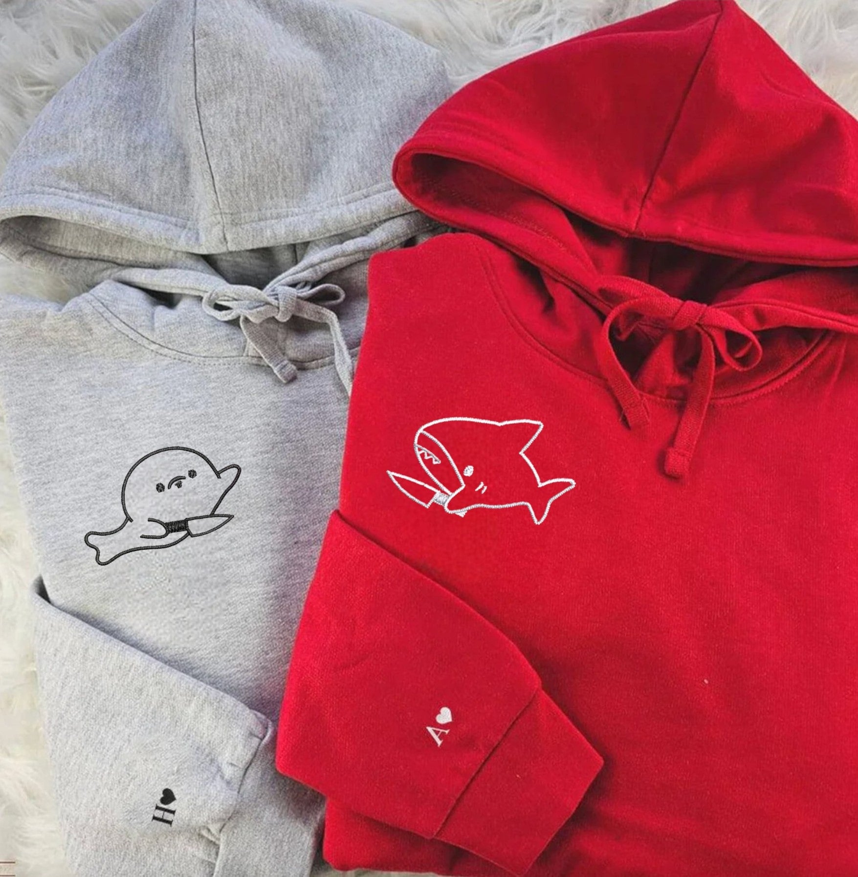 Matching Shark and Seal Couple Sweatshirts with fun embroidered knife designs.