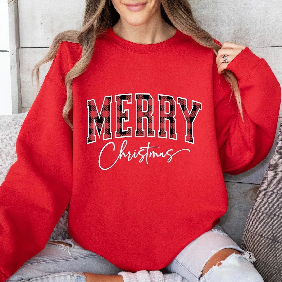 Holiday-themed sweatshirt with bold plaid and script text
