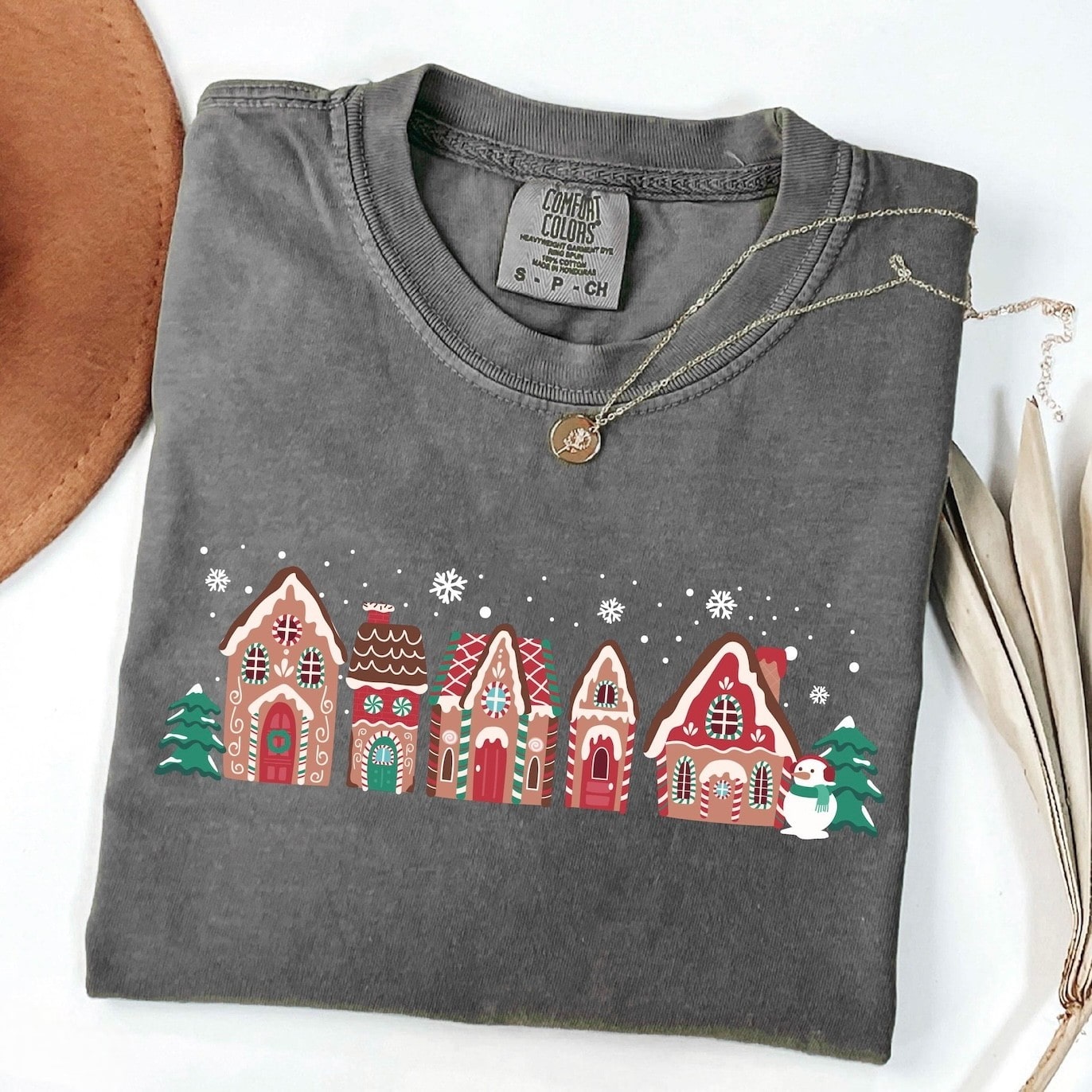 Green Christmas sweatshirt with a gingerbread house village design
