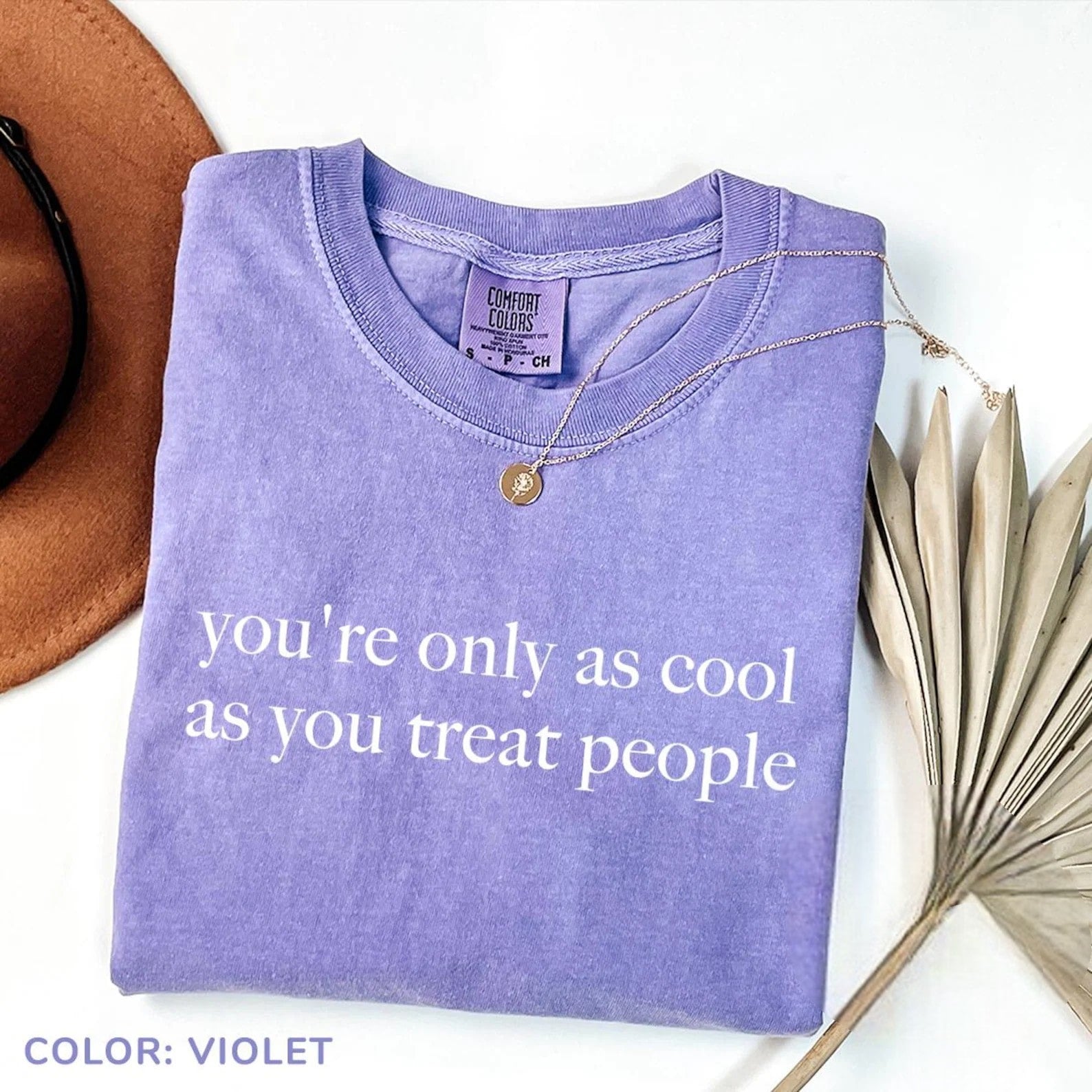 Violet graphic tee with the quote "You’re Only as Cool as You Treat People."