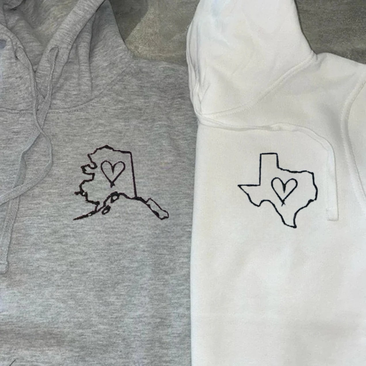 Customizable state and heart embroidered sweatshirts celebrating connection across miles.