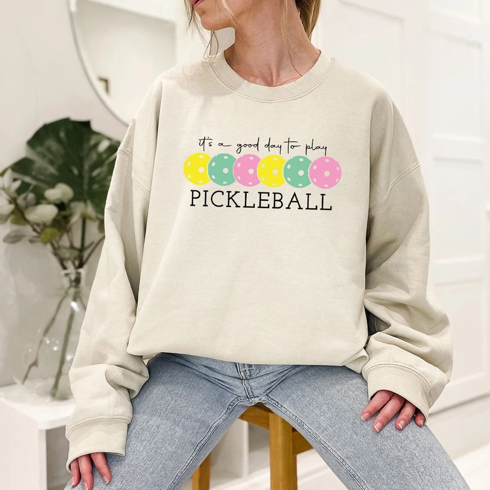 Beige sweatshirt with colorful pickleball graphics and 'It's a Good Day to Play Pickleball' text