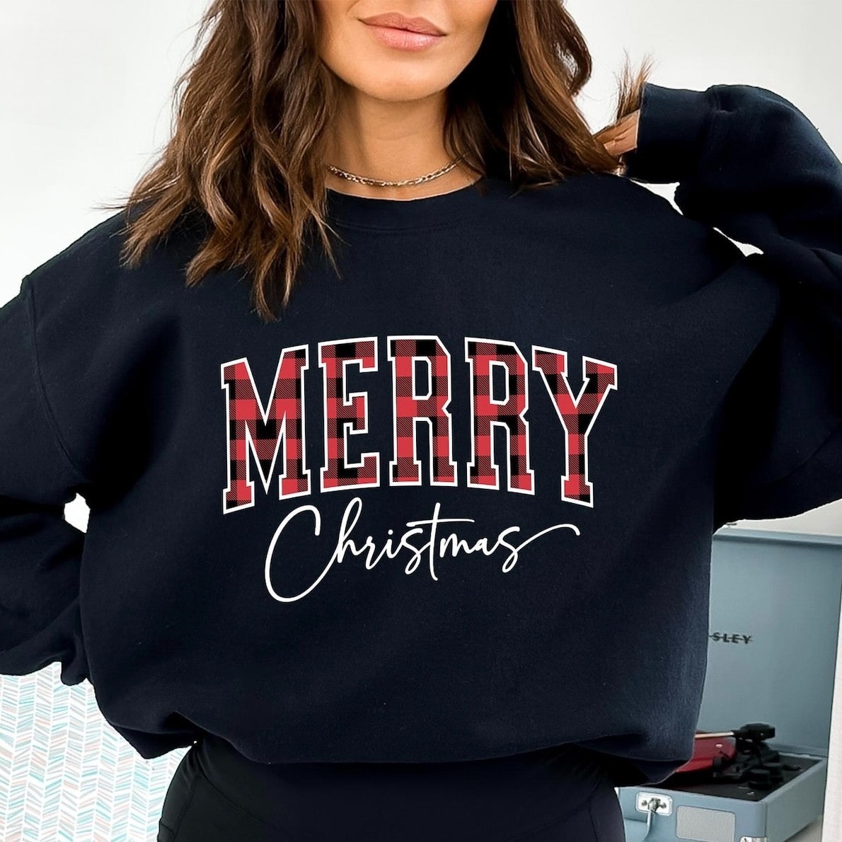 Cozy Christmas sweatshirt featuring festive plaid lettering
