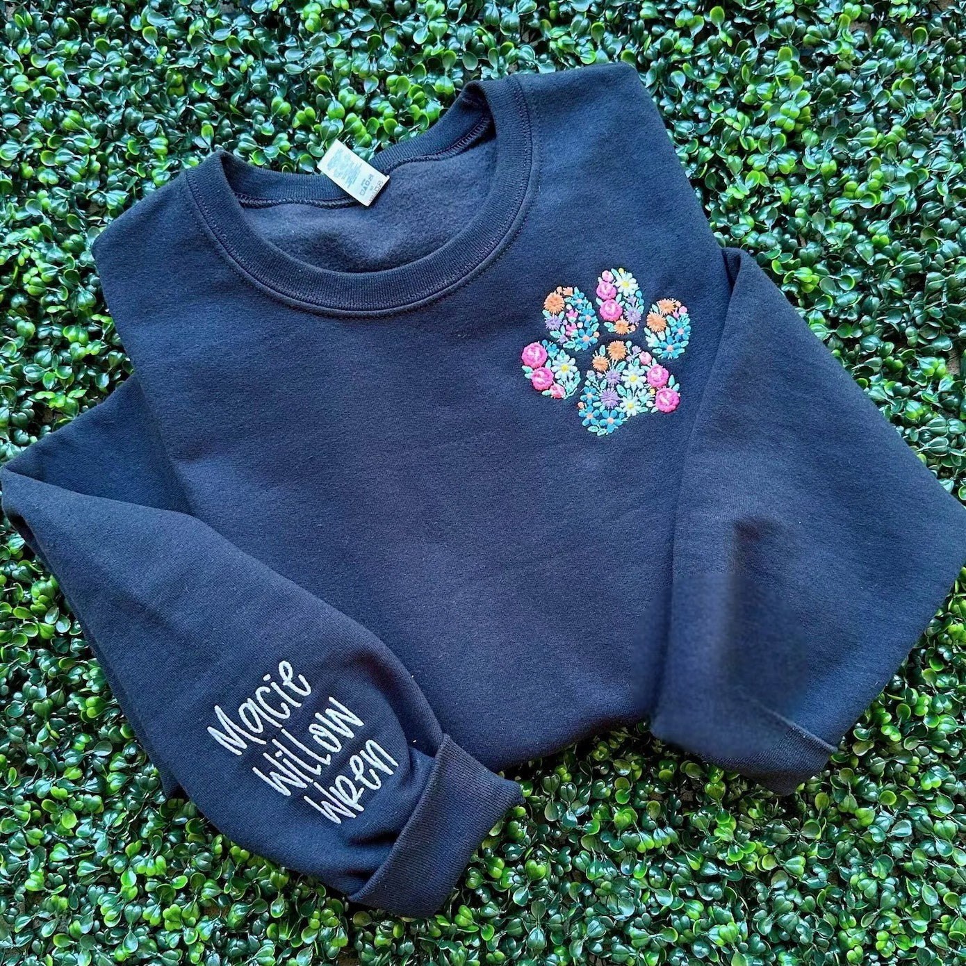 Personalized floral paw print sweatshirt with embroidered design.