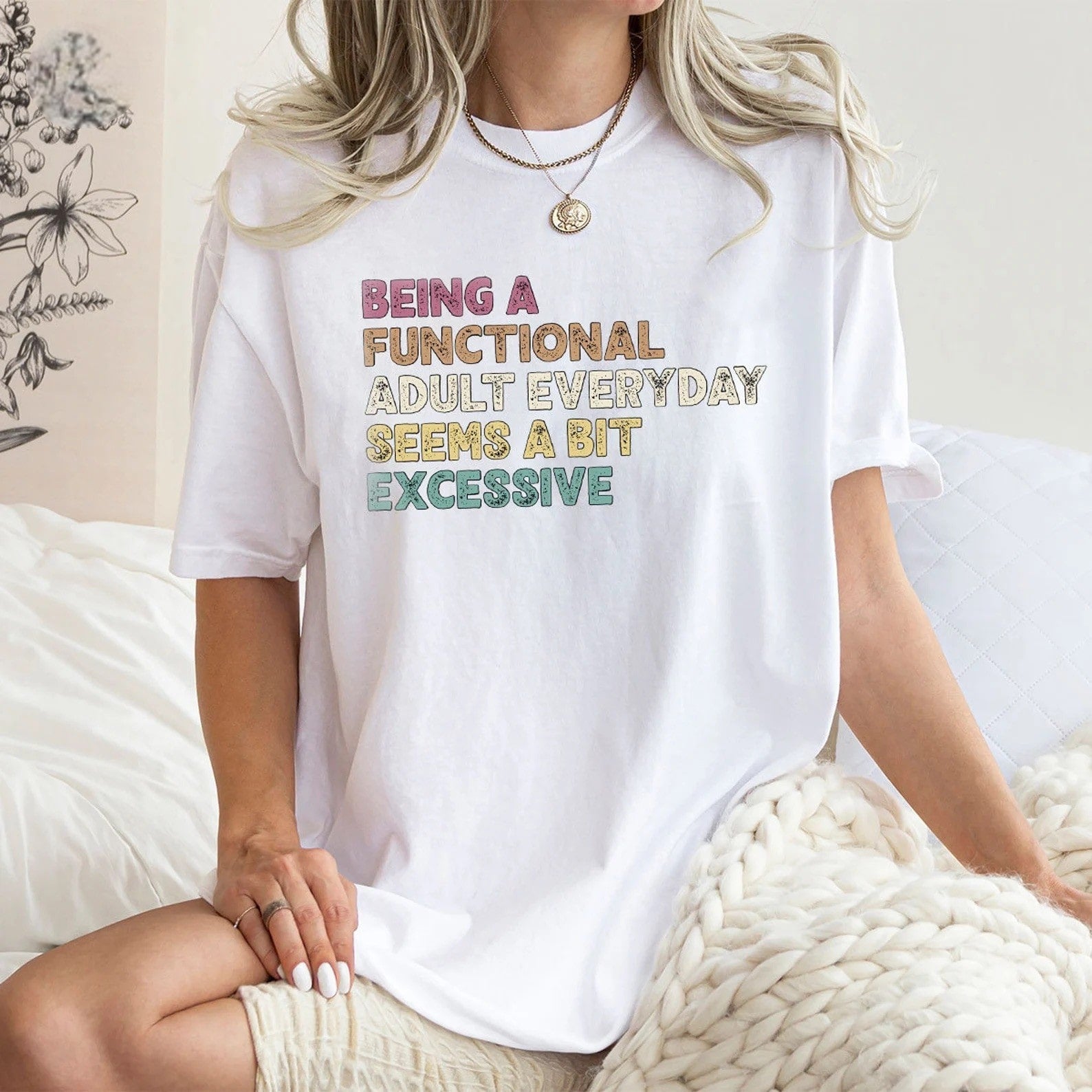 White tee with playful "Being a Functional Adult" graphic in bright colors.