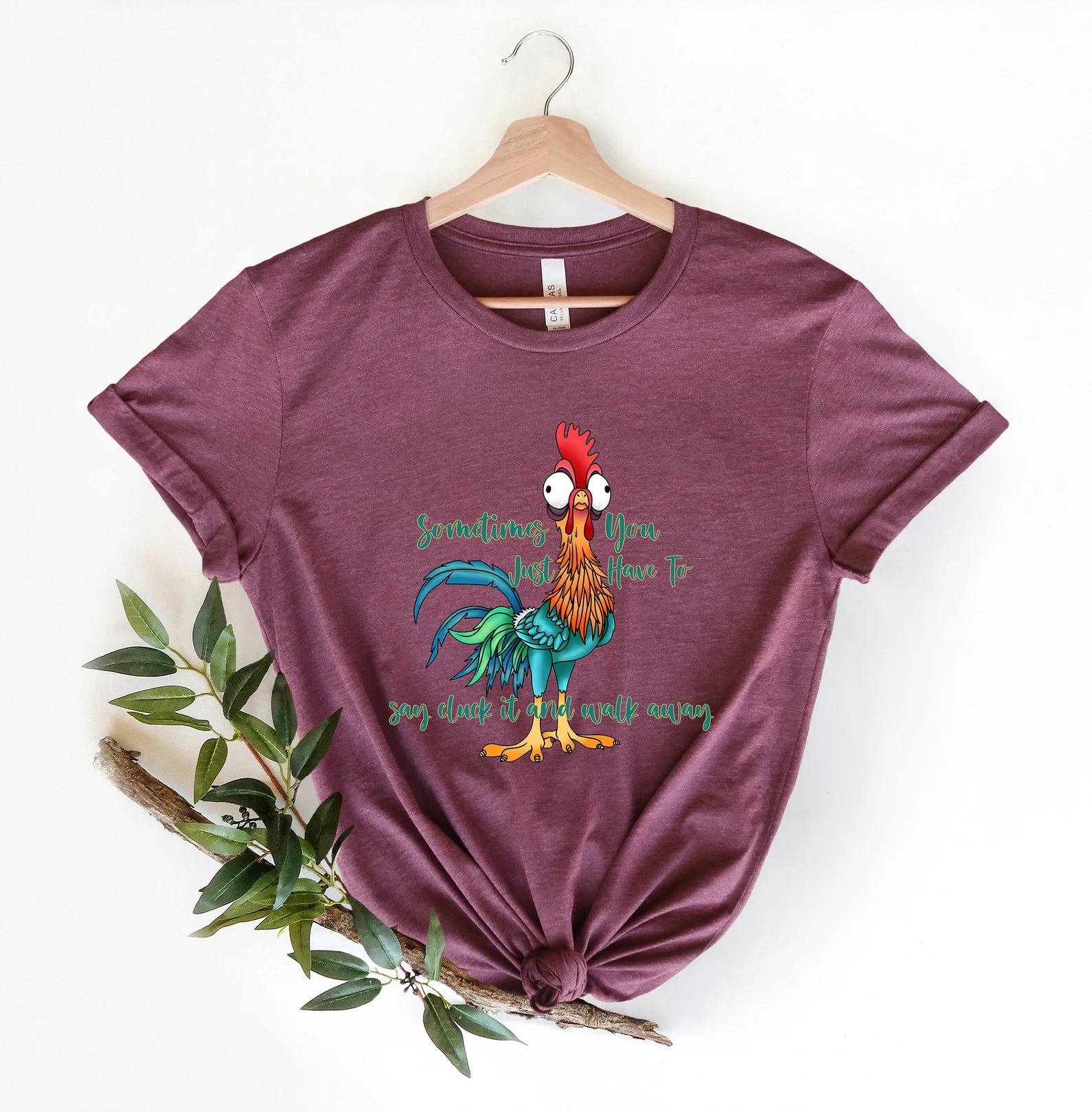 Colorful "Cluck It and Walk Away" rooster tee in a vibrant purple color.