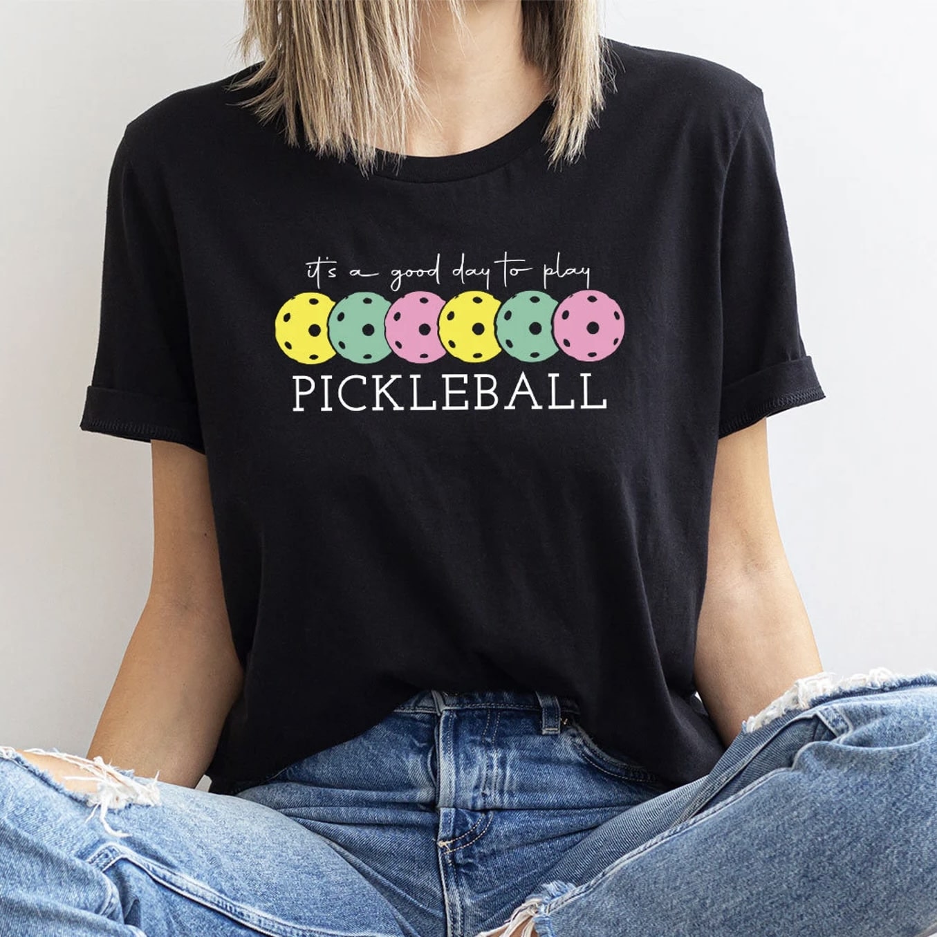 Black t - shirt featuring vibrant pickleball design and 'It's a Good Day to Play Pickleball' message