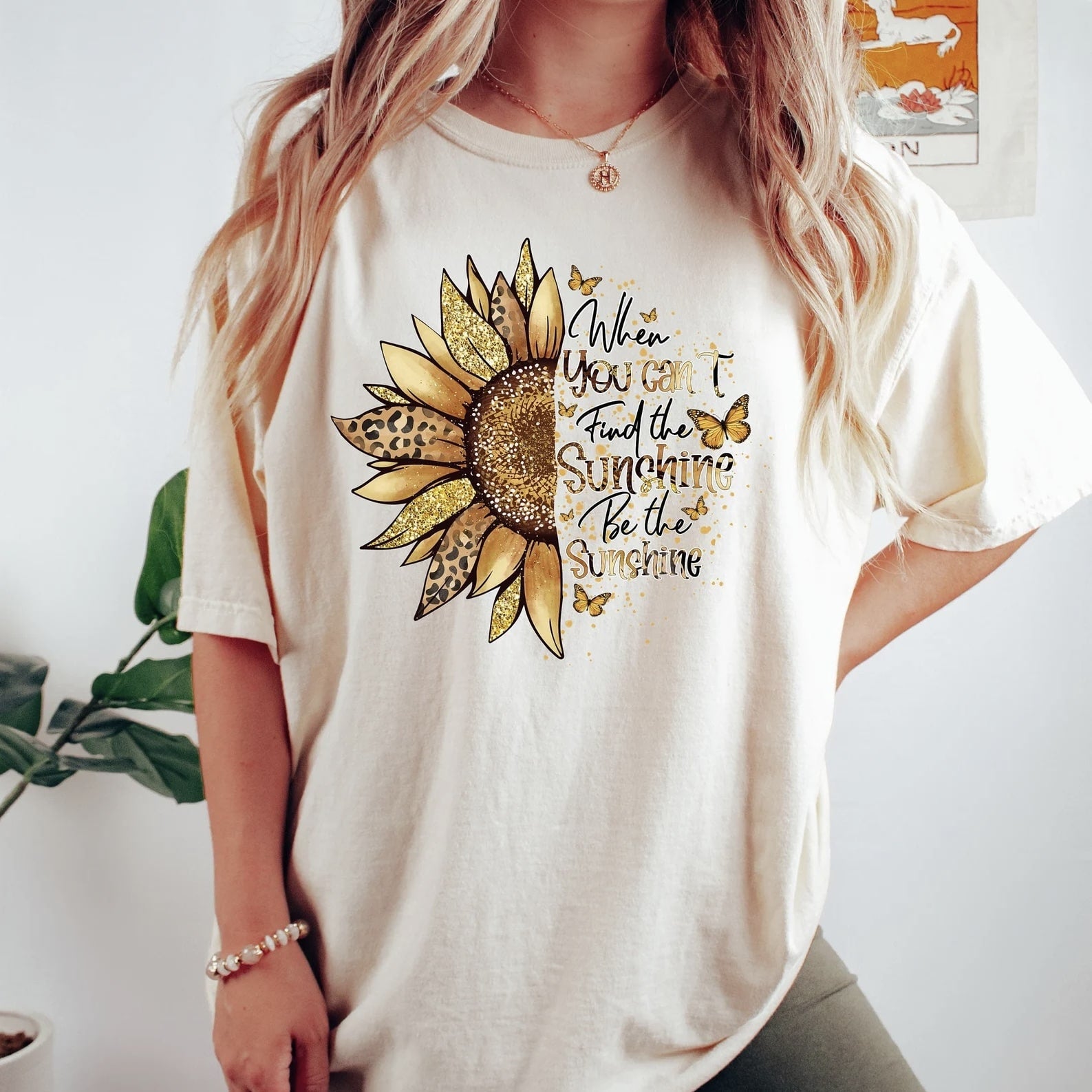 Sunflower graphic tee with the inspirational quote 'When you can't find the sunshine, be the sunshine' in gold and black text