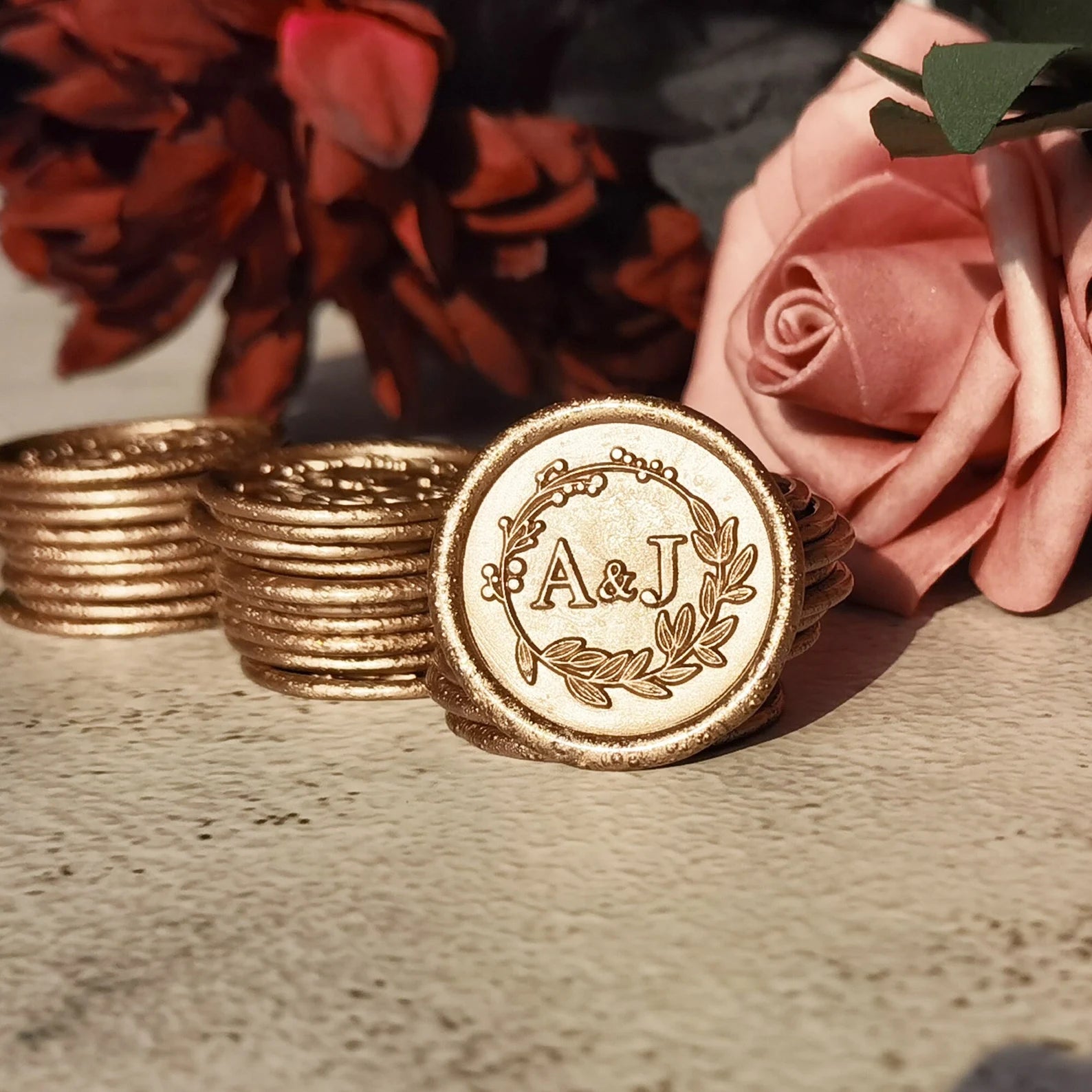 Gold wax seal with leaf logo for wedding stationery.