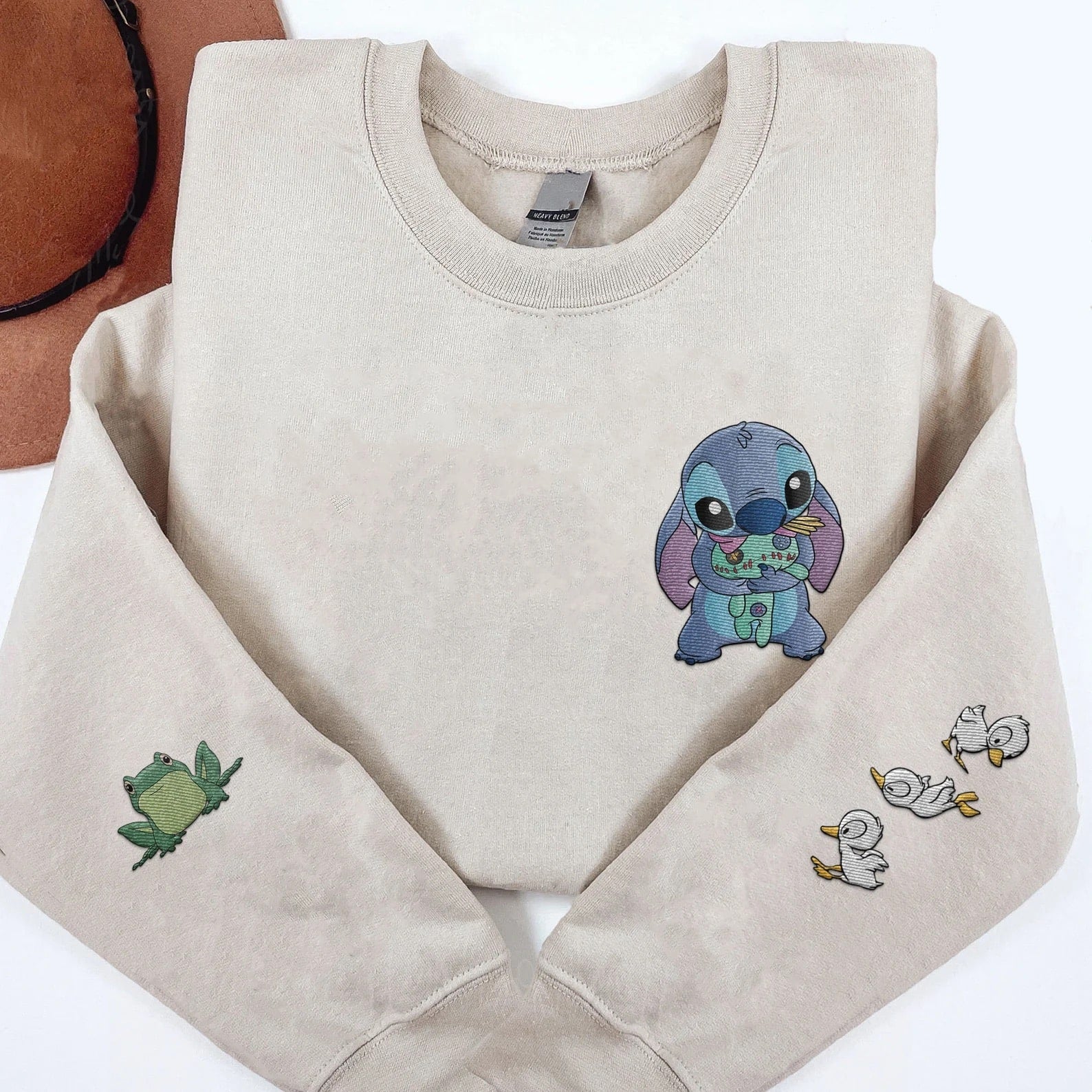 Cute Disney-inspired sweatshirt featuring Stitch holding Scrump