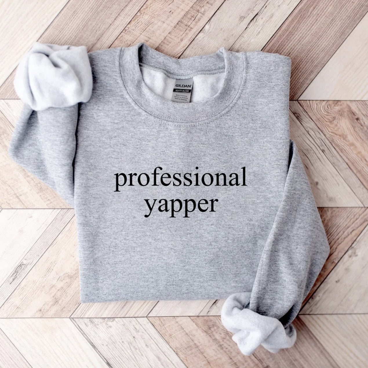 Close-up of gray sweatshirt with minimalist "Professional Yapper" print