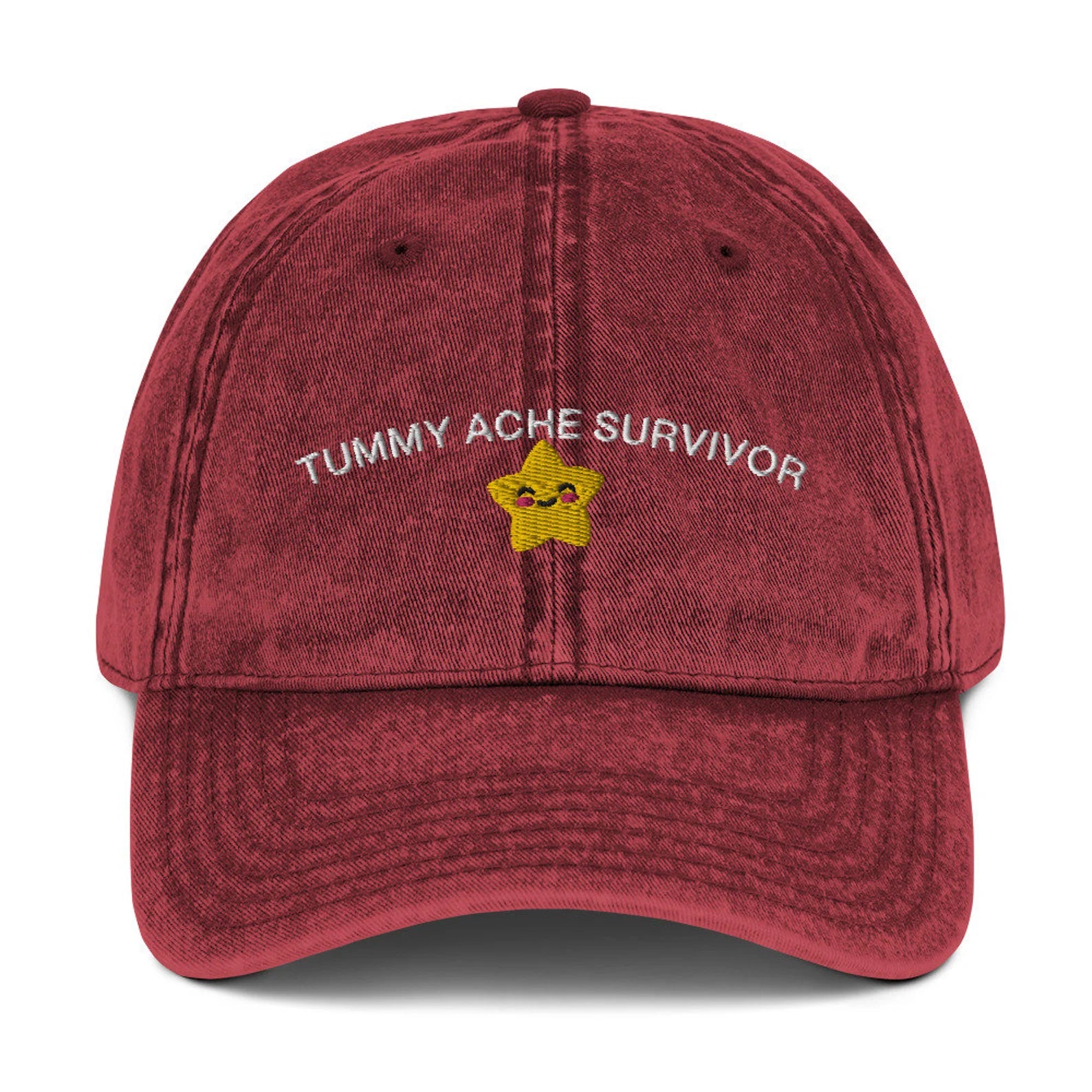 Red "Tummy Ache Survivor" cap featuring playful embroidered star