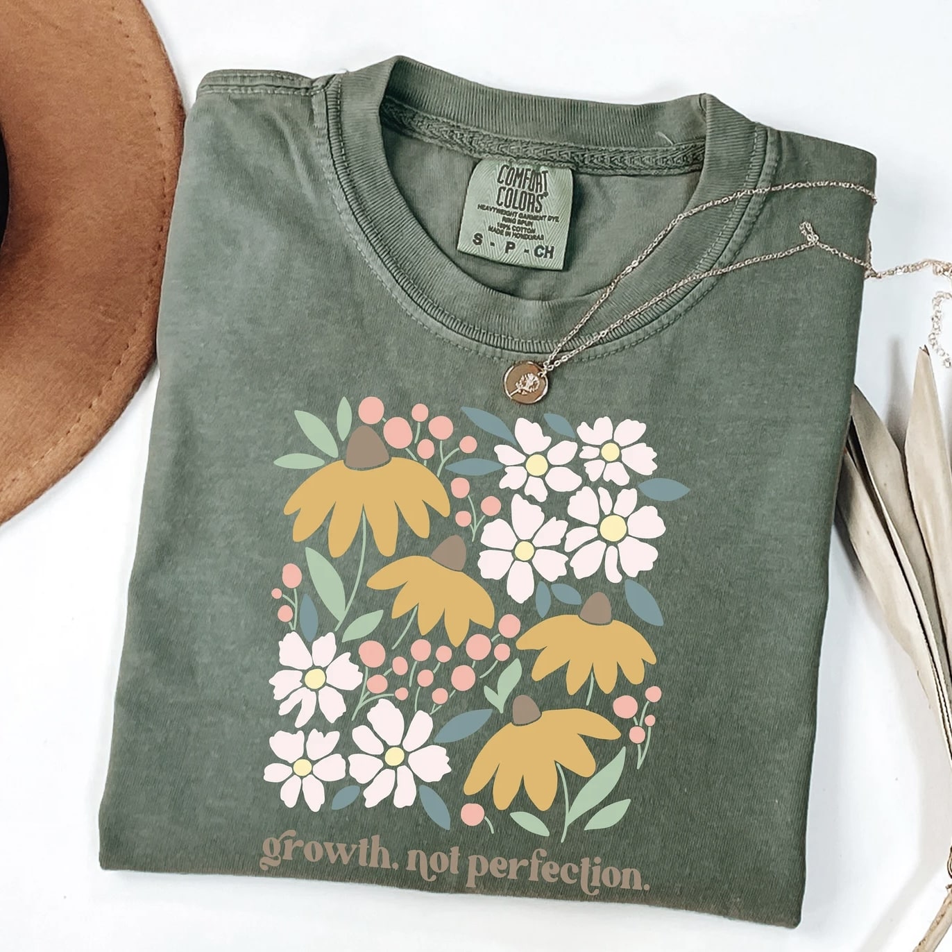 Green "Growth, Not Perfection" t-shirt with colorful floral design