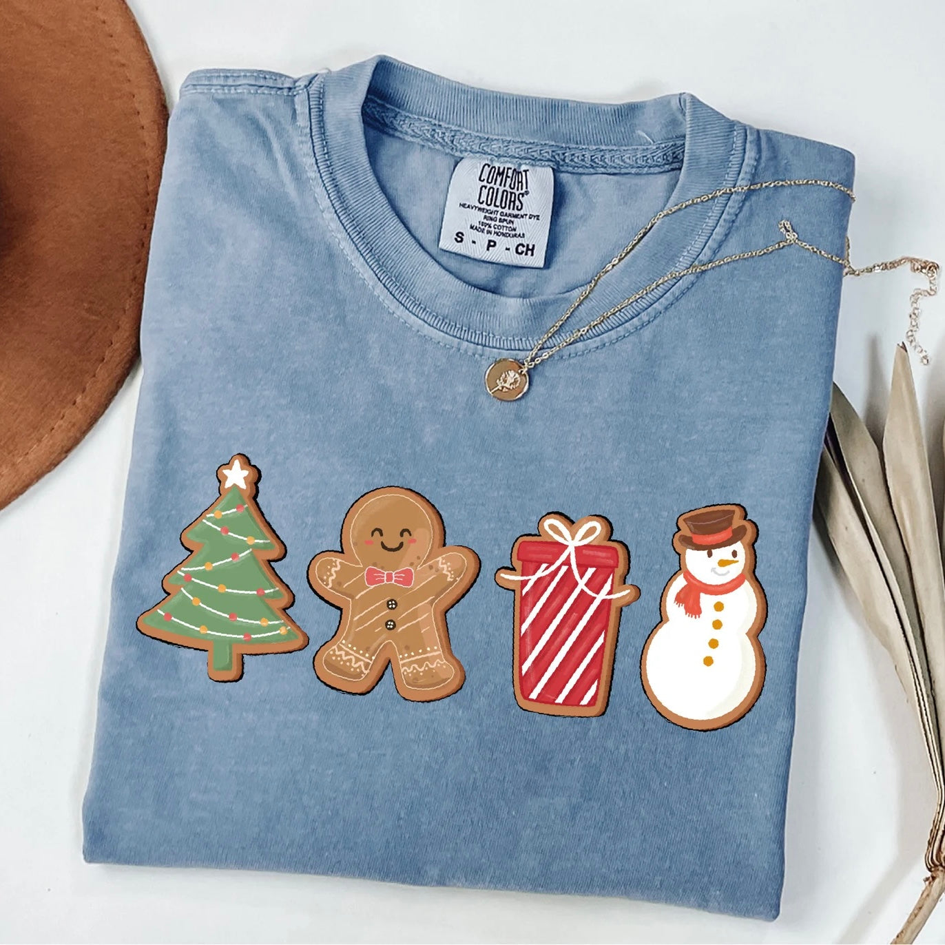 Holiday graphic t-shirt featuring colorful Christmas cookies like snowman, tree, and gingerbread man.