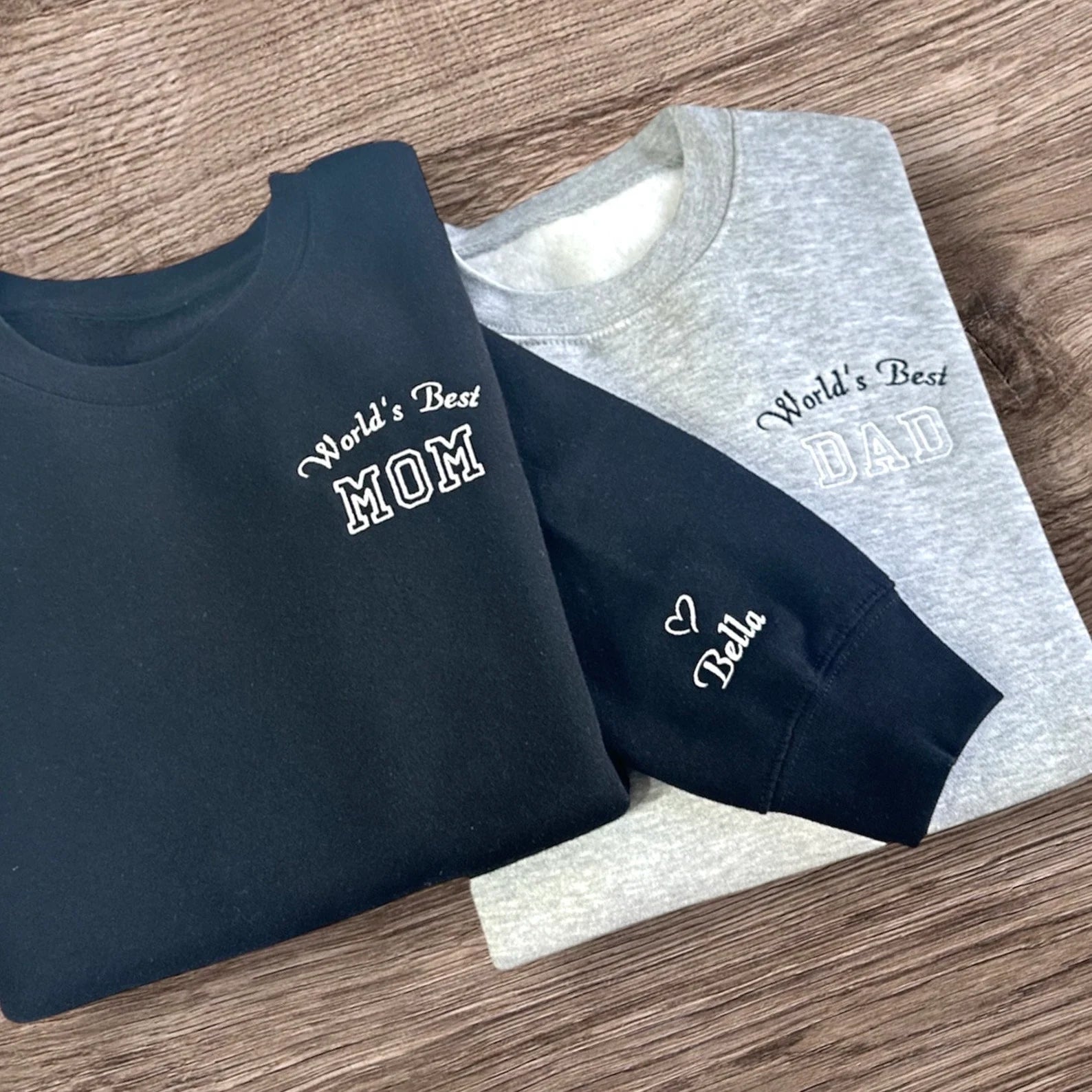 Matching "World's Best Mom & Dad" sweatshirts with custom sleeve personalization.