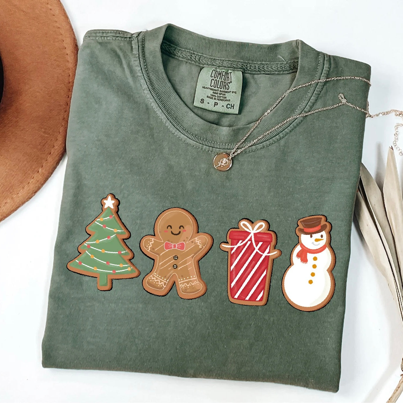 Christmas graphic tee with holiday-themed cookies: tree, gingerbread man, gift, and snowman.